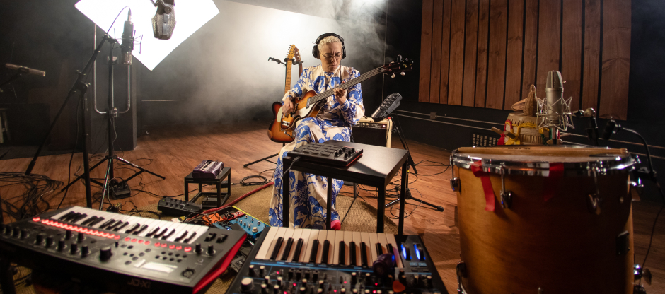 Maria Gadú em estúdio, tocando um instrumento enquanto grava seu documentário